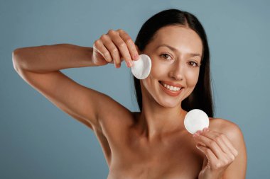 Kaldırmak için makyaj yap. Genç kadın stüdyoda arka planda..