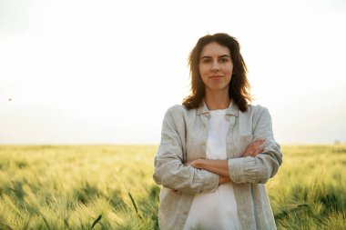 Kollarını kavuşturmuş duruyorsun. Beyazlı kadın tarla tarlasında..