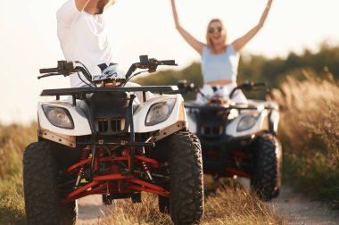 Neşeli yüz ifadesi. Erkek ve kadın dışarıda ATV 'deler..