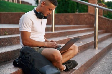 Günlük kıyafetlerle. Genç erkek öğrenci dışarıda..