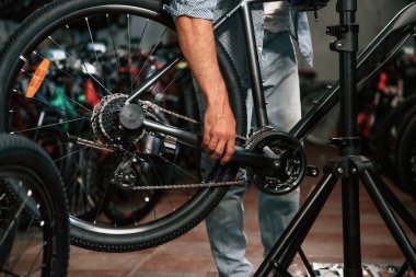 Bisikleti tamir eden adamın ellerine yakından bakın..