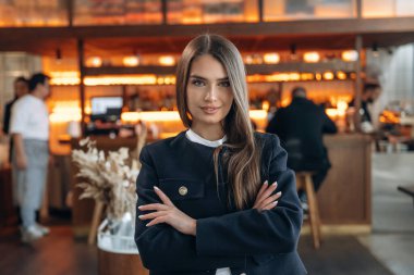 Arka planda insanlar var. Restoran sahibi ya da müdürü içeride bekliyor..