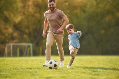 Nasıl futbol oynanacağını öğretiyorum. Mutlu baba ve oğul yazın sahada eğleniyorlar..