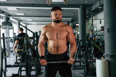 Güçlü kaslı adam spor salonunda çalışıyor..