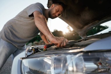 Bozuldu, kaput açıldı, tamir ediliyor. Adam dışarıda arabasıyla bekliyor..