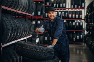 Rafta, lastiği alıyor. Tekerlekleri ve tekerlekleri olan tamirci var..