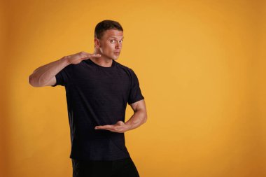 Görünmez afişi elinde tutuyor. Adam stüdyoda arka plana karşı..