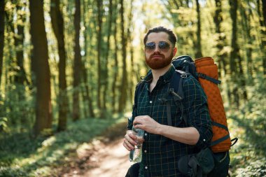 Sırt çantasıyla. Sakallı adam gündüz vakti ormandadır..
