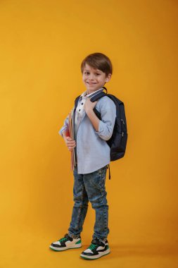 Küçük çocuk sarı arka planda stüdyoda..