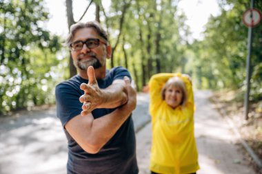 Egzersizleri ısıt, spor yap. Doğada üst düzey çiftler birlikte..