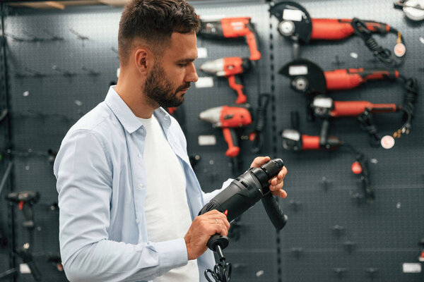 Проверяю дрель. Мужчина в хозяйственном магазине..