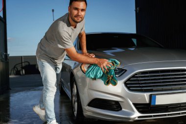 Araba yıkama, cilalama işi. Adam dışarıda otomobille geziyor..