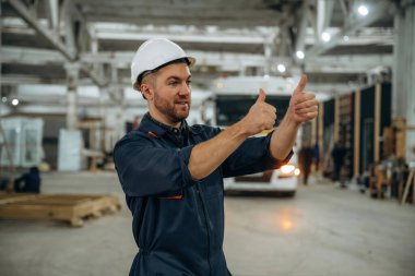 Eller hareket eder, aracı park etmeye yardım eder. Erkek işçi, modern depo veya imalat şirketinde çalışıyor..