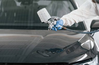 Spreyciyle araba boyayan adamın yakın görüntüsü..