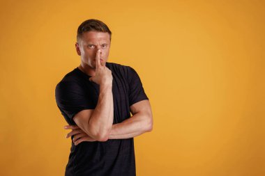 Düşünceli bir yüz ifadesi. Adam stüdyoda arka plana karşı..