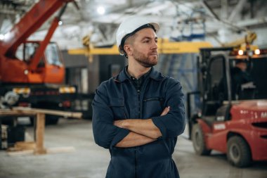 Ön manzara, ayakta. Erkek işçi, modern depo veya imalat şirketinde çalışıyor..