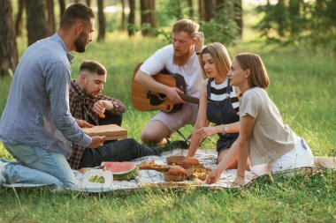 Yere yatın! Bir grup arkadaş, ekolojik kutularda yiyeceklerle sahada piknik yapıyorlar..