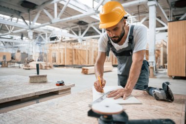 Masanın yanında. Ahşap depoda sanayi işçisi..