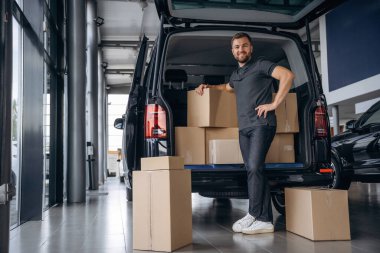 Bir sürü kutu. Teslimatçı ya da yükleyici arabanın yanında..