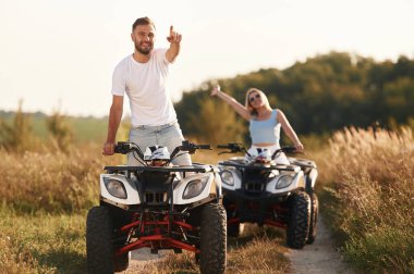 Açık kırsal yolda. Erkek ve kadın dışarıda ATV 'deler..