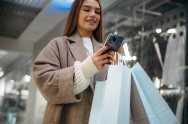 Aşağıdan bak, akıllı telefonla. Alışveriş merkezinde güzel bir kadın var, alışveriş anlayışı..
