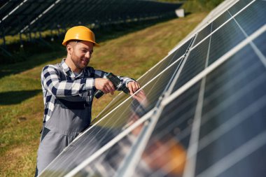 Elde matkap. Gündüz vakti fotovoltaik güneş panelleri olan bir mühendis..