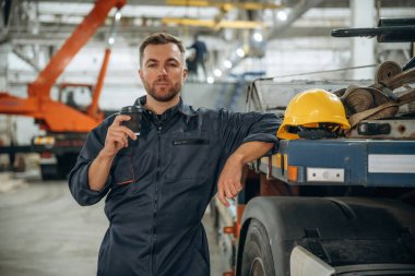 Mola veriyoruz, bir bardak içkiyle. Erkek işçi, modern depo veya imalat şirketinde çalışıyor..