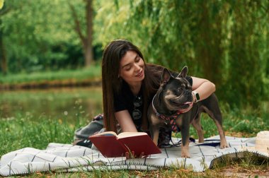Hayvanlara bakıyorum, kitaplarla, uzanarak. Genç güzel bayan köpeğiyle birlikte parkta..