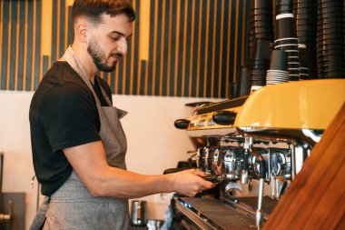 Özel bir makine kullanarak içki koyuyor. Adam lezzetli sokak yemekleri sunuyor..