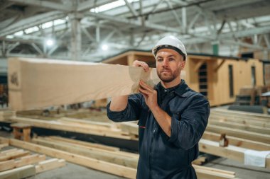 Tahta tahta ellerde. Erkek müteahhit ev inşaatında..