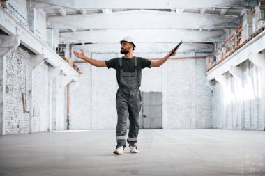 Beyaza boyanmış. Erkek işçi boş depoda..