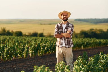 Kollarını kavuşturarak. Çiftçi tarım alanında..
