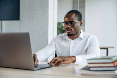 Laptop kullanıyorum. İşadamı modern ofiste çalışıyor..