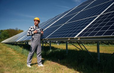 Photovoltaik güneş panelleri olan neşeli mühendis gündüz vakti dışarıda..