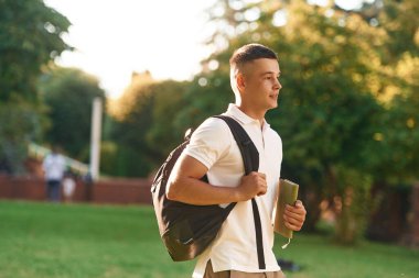 Sırt çantasıyla. Genç erkek öğrenci dışarıda..