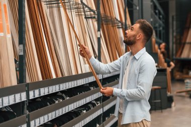 Büyük parke seçimi olan bir depo. Adam hırdavatçıda..