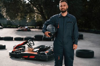 Ayakta duran ve kaskını tutan. Erkekler açık havada, kart yarışı gebeliği..