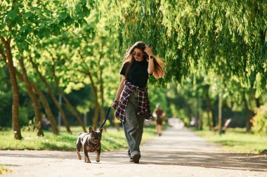 Yürüyüş yapıyorum. Genç güzel bayan köpeğiyle birlikte parkta..