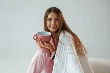 Büyük bir bardak içki. Günaydın, uyanıyorum. Genç ve güzel bir bayan stüdyoda arka plana karşı..