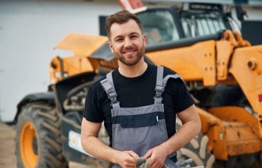 Elleri temizleyecek kumaşla iyi iş çıkardın. Adam traktörle birlikte. Tarım işçisi.