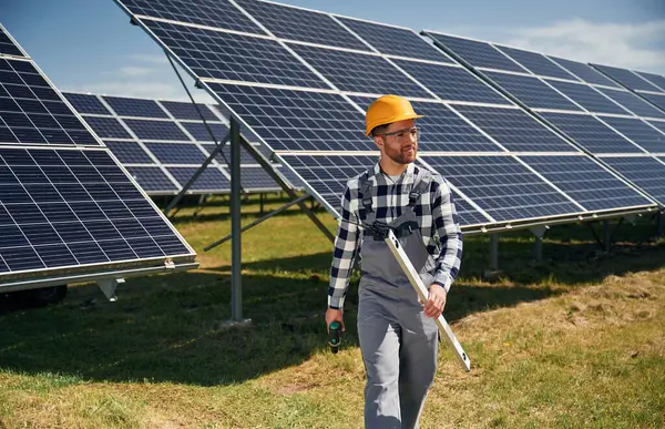 Çalışmaya hazır, matkapla. Gündüz vakti fotovoltaik güneş panelleri olan bir mühendis..