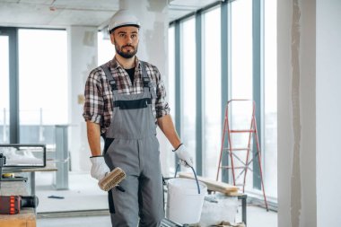 Duvarları boyayacağım. Bir adam bitmemiş bir odayı yeniliyor..