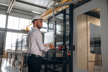 Müdürü beyaz gömlekli. İnsanlar modern fabrikada çalışıyor..