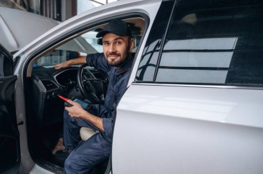 Mola zamanı, otomobilde oturmak. Araba tamirhanesinde çalışan bir tamirci..