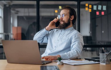 Telefonla konuşuyorum. İşadamı ofiste çalışıyor..