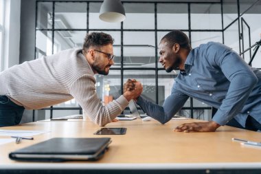 İki ofis çalışanı eğleniyor ve bilek güreşi yapıyor..