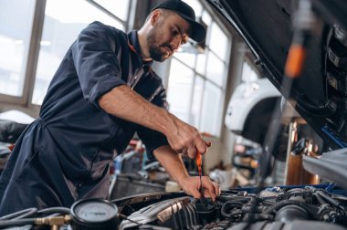 Nakil aracı tamir ediliyor. Araba tamirhanesinde çalışan bir tamirci..