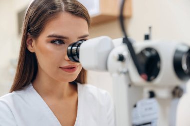 Dijital optik cihaz. Genç bayan göz doktoru kabinede..