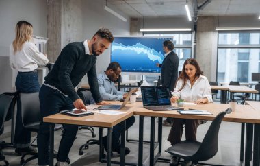 Masanın yanında. Bir grup ofis çalışanı içeride birlikte..