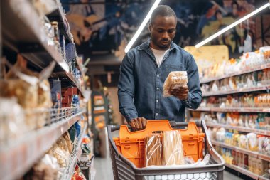 Alışveriş arabasıyla. Erkek müşteri süpermarkette..